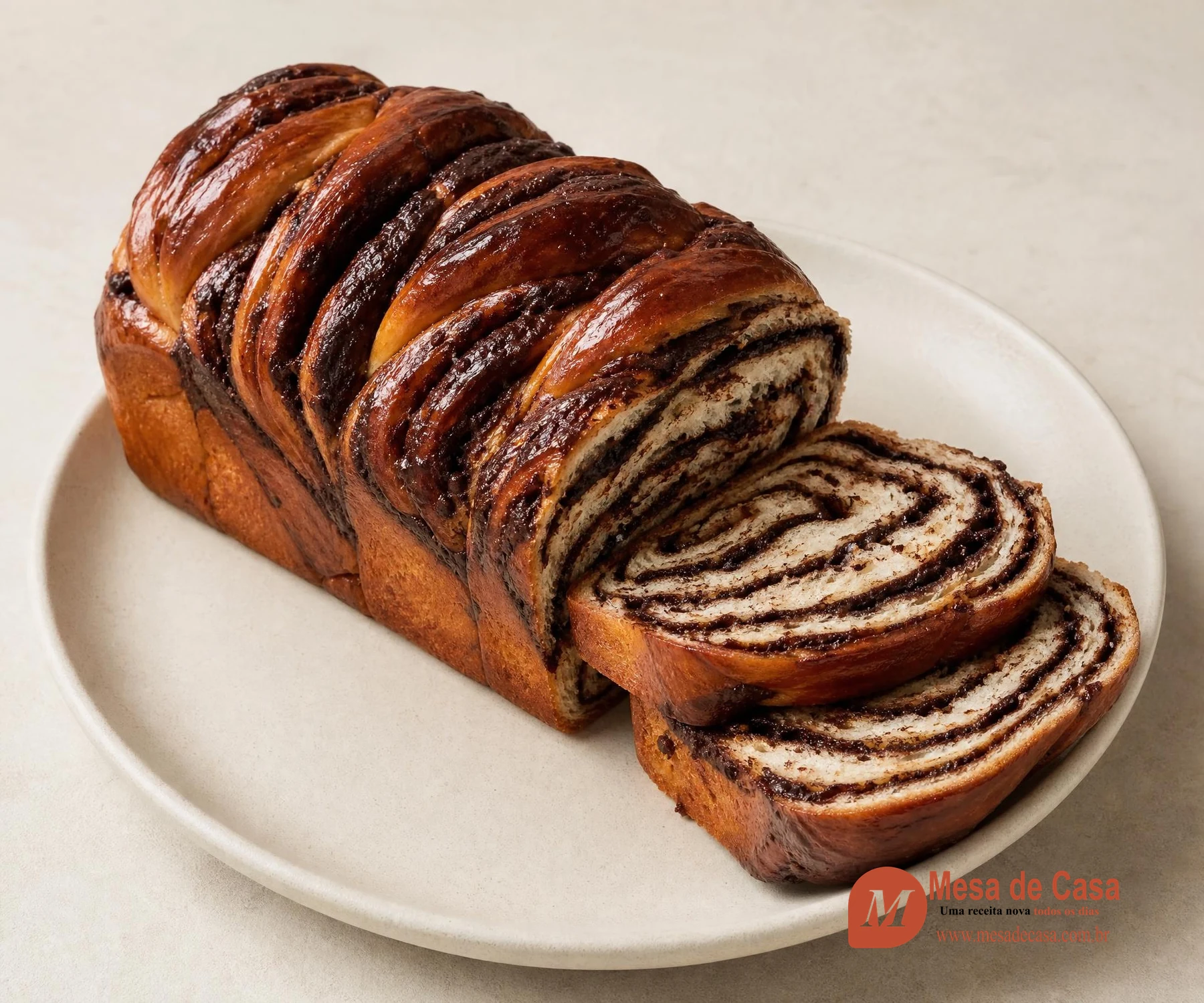 Babka de chocolate trançada com duas fatias mostrando espirais escuras de cacau