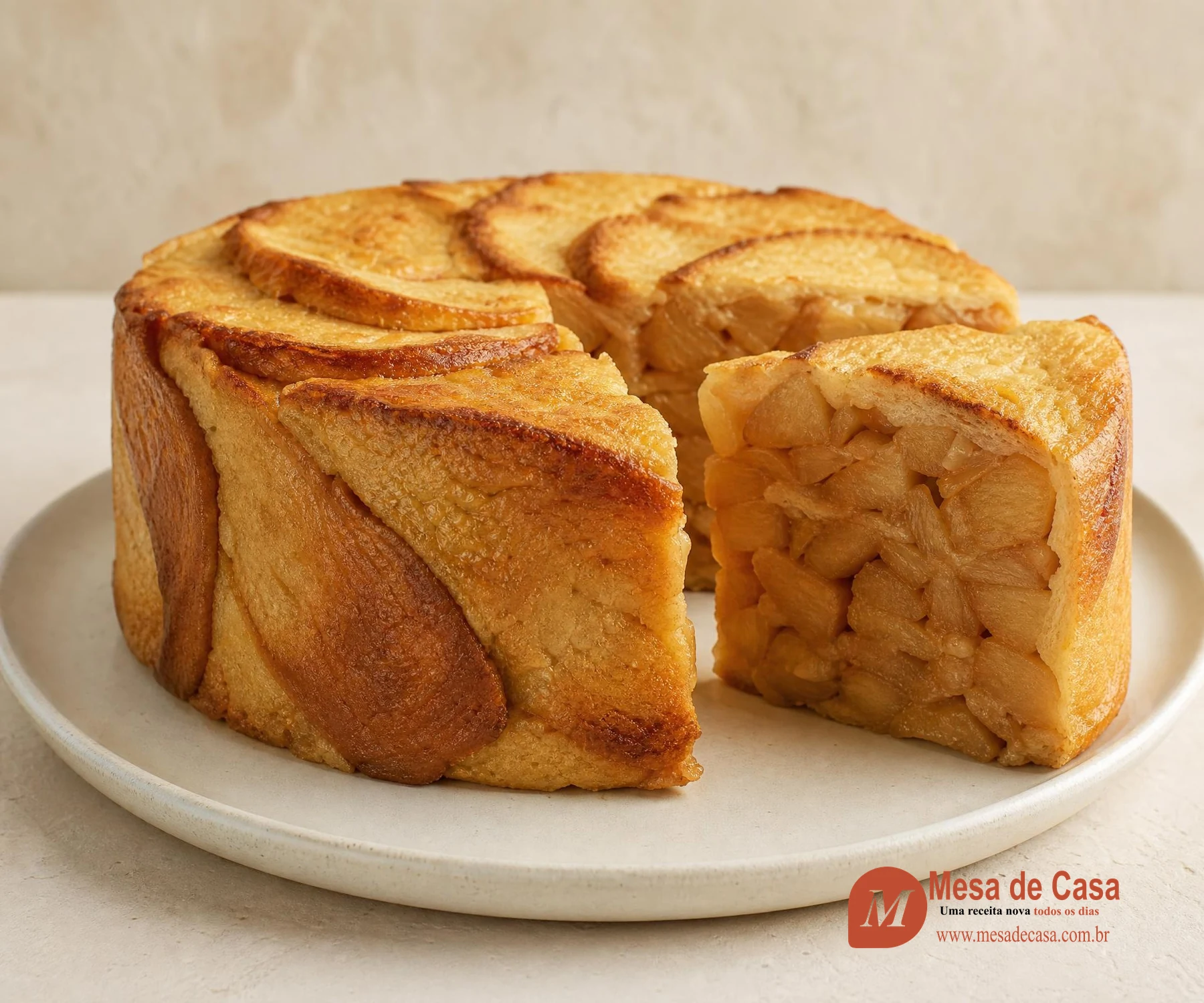 Charlotte cilíndrica de pão dourado com uma fatia mostrando maçãs caramelizadas