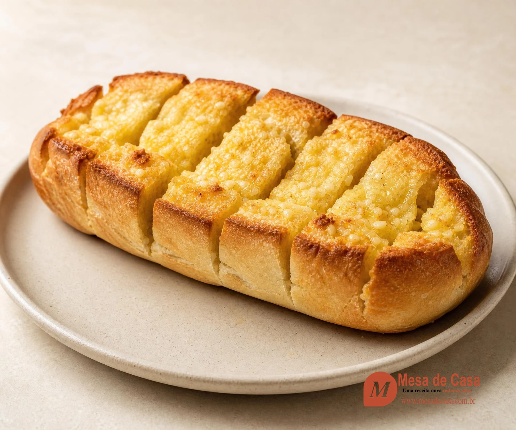 Pão de alho assado aberto em porções com miolo amanteigado e bordas douradas