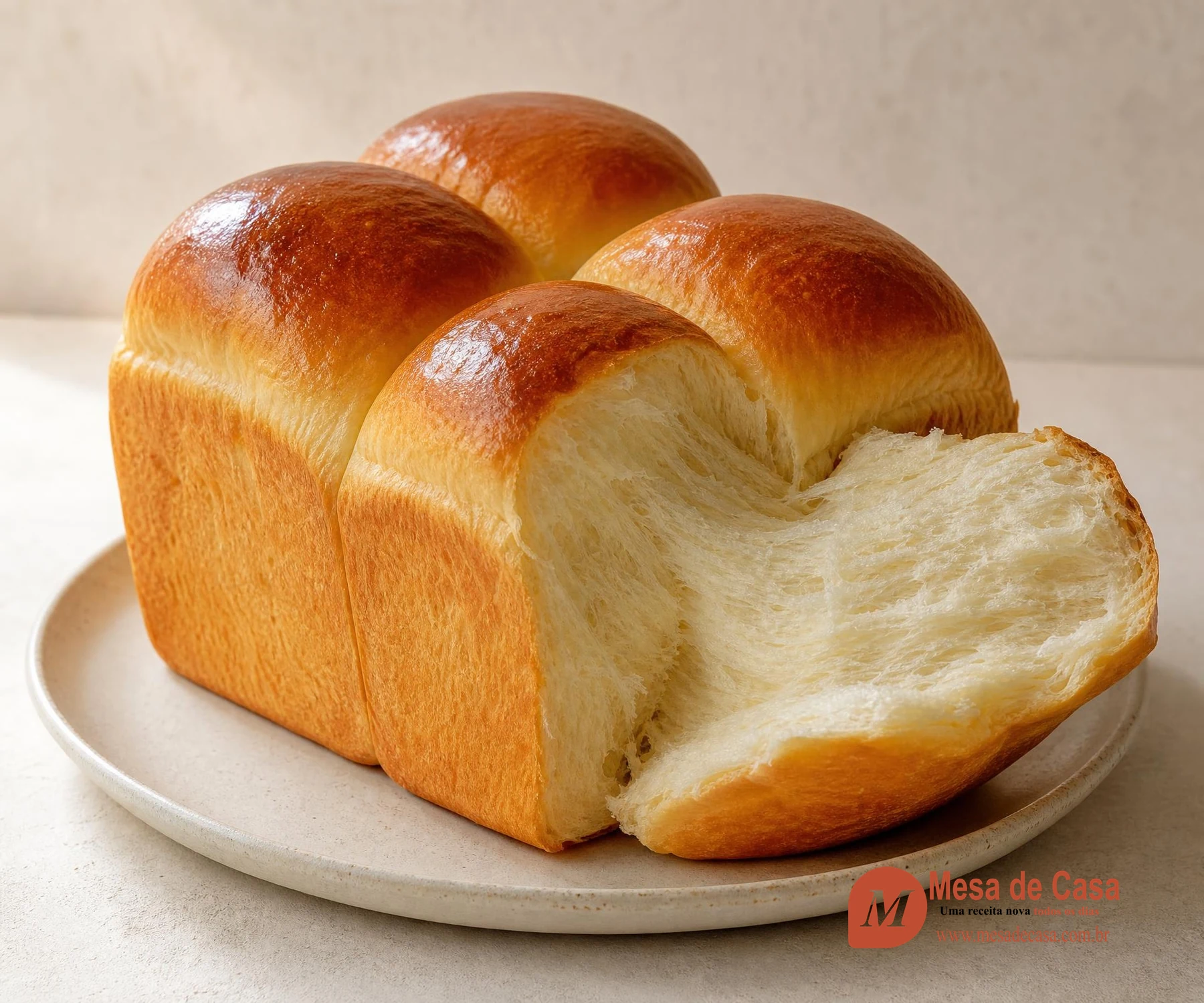 Pão de leite japonês alto com quatro lóbulos dourados e miolo branco fibroso