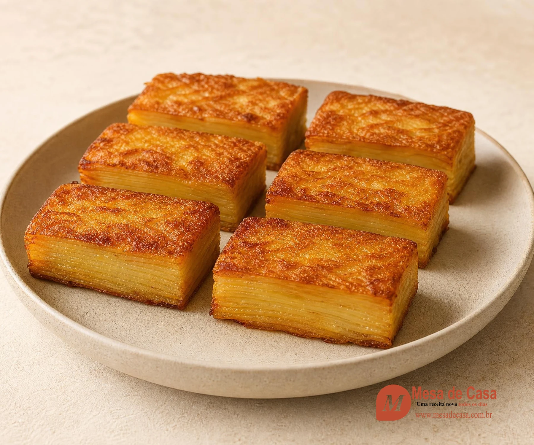 Seis blocos dourados de pavê de batata com muitas camadas horizontais finas