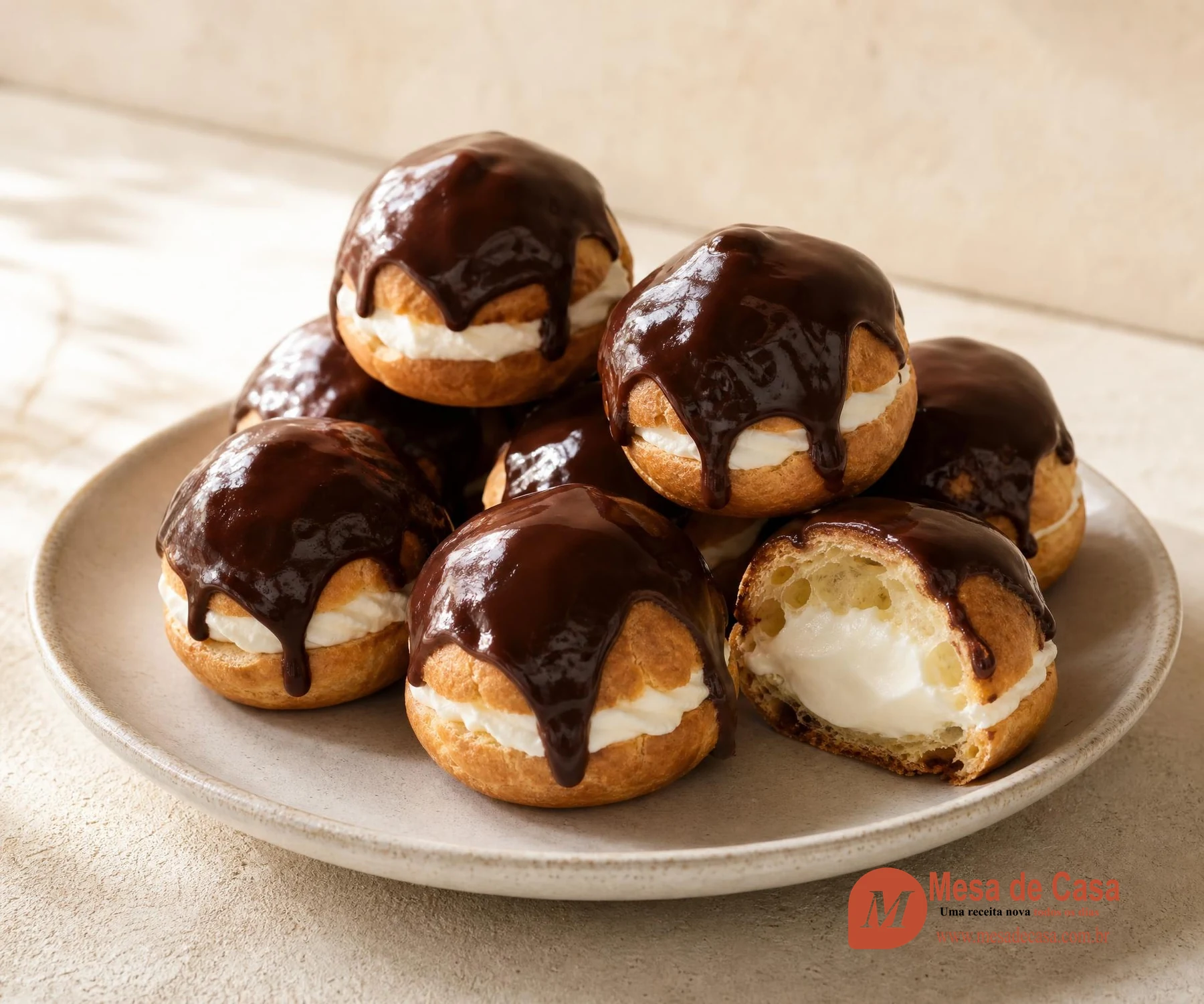 Profiteroles dourados recheados com creme branco e cobertos por molho de chocolate escuro