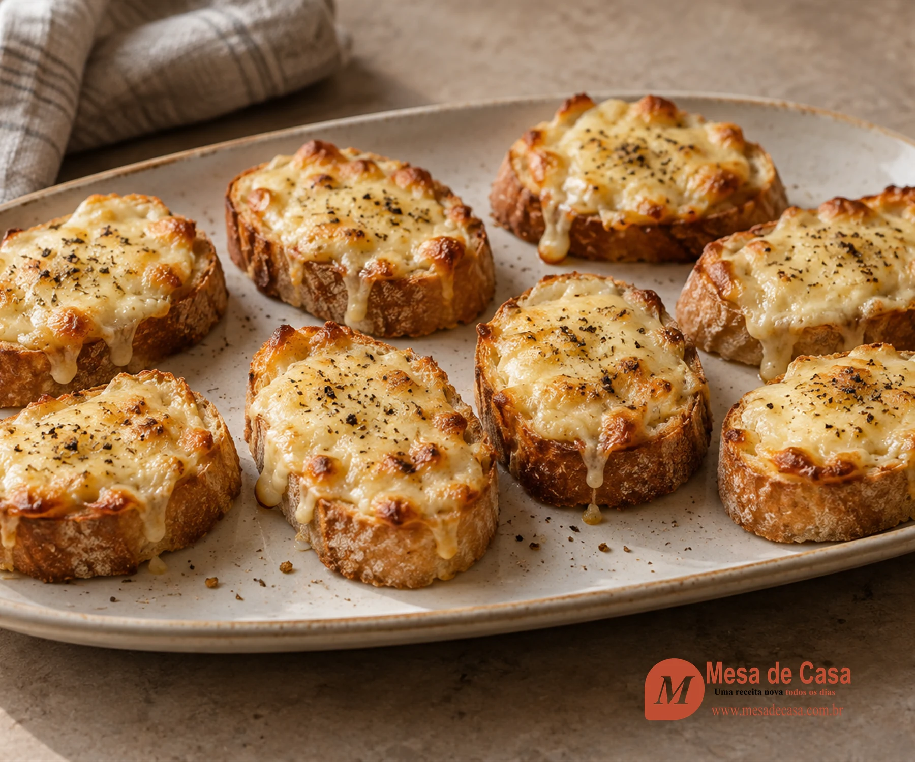 Crostini de pão dourado cobertos por queijo Gruyère derretido e pimenta preta