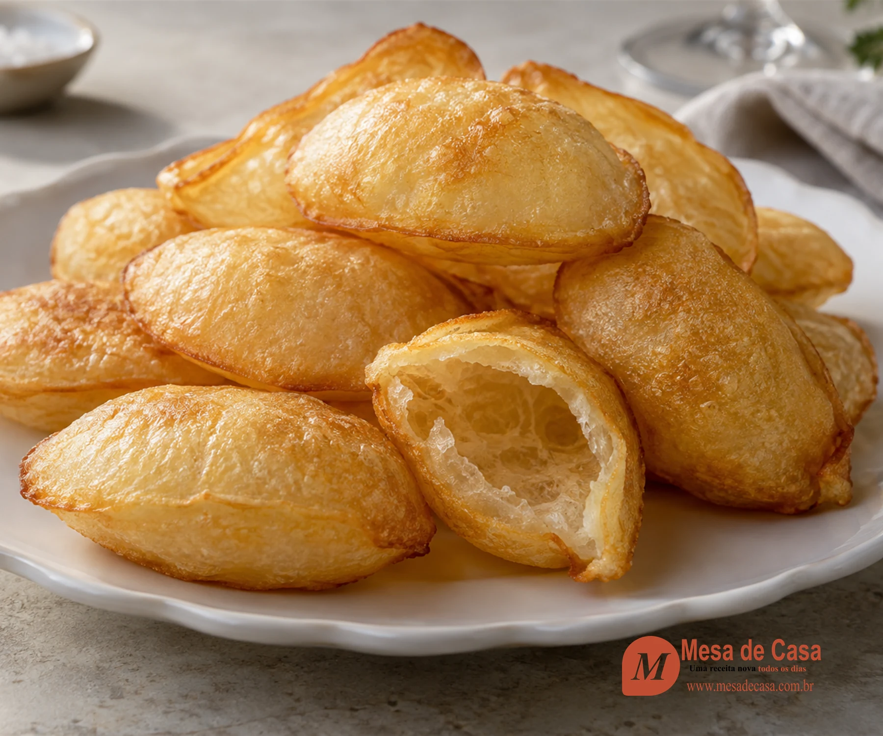 Pommes soufflées douradas e ocas, com uma aberta mostrando a cavidade interna